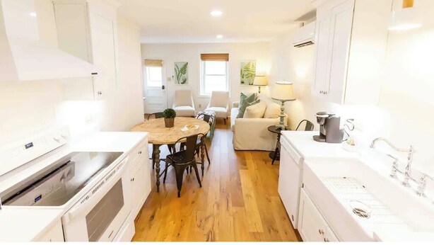 A modern kitchen with white appliances, a dining area with a wooden table and chairs, and a living area with a sofa and a lamp. - Historical Hotel, Main Street Blowing Rock (Blowing Rock)