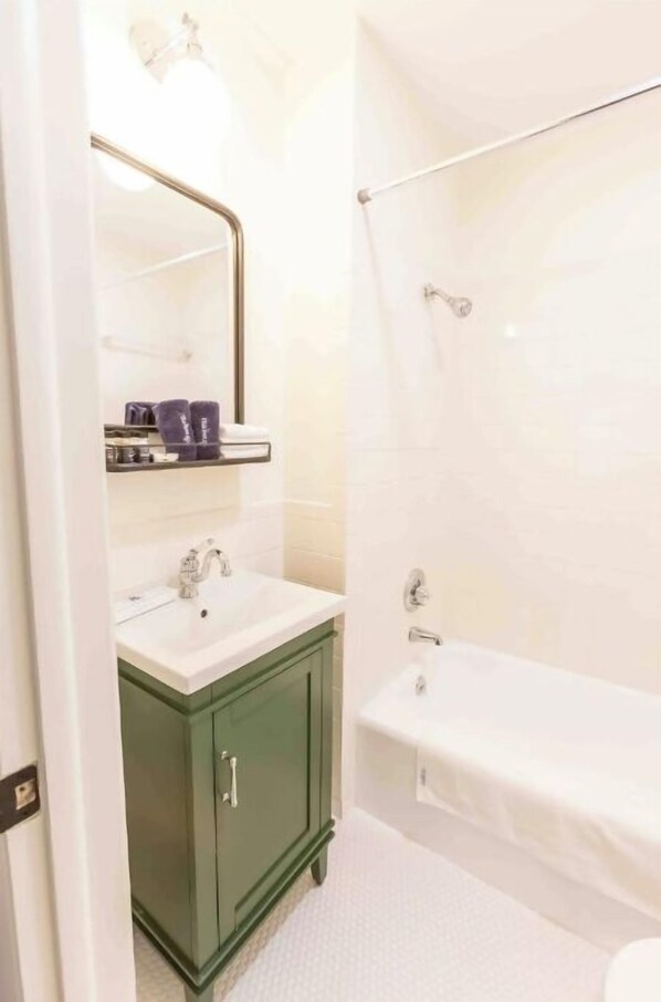 A bathroom with a white sink, green cabinet, and a bathtub. - Historical Hotel, Main Street Blowing Rock (Blowing Rock)
