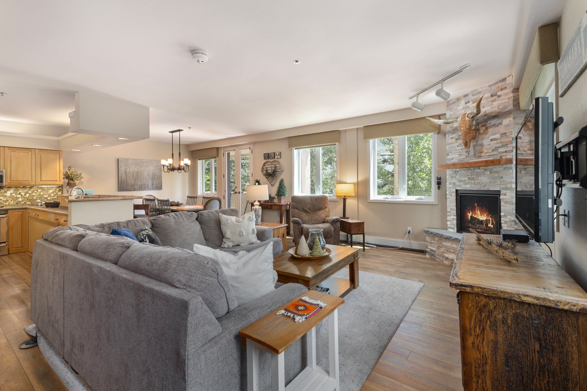 A modern living room with a grey sofa, a wooden coffee table, and a fireplace.