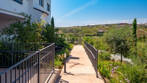 A pathway leading to a building with a view of a hilly landscape. - Lotus 2341 Golf beach & pool (Casares)