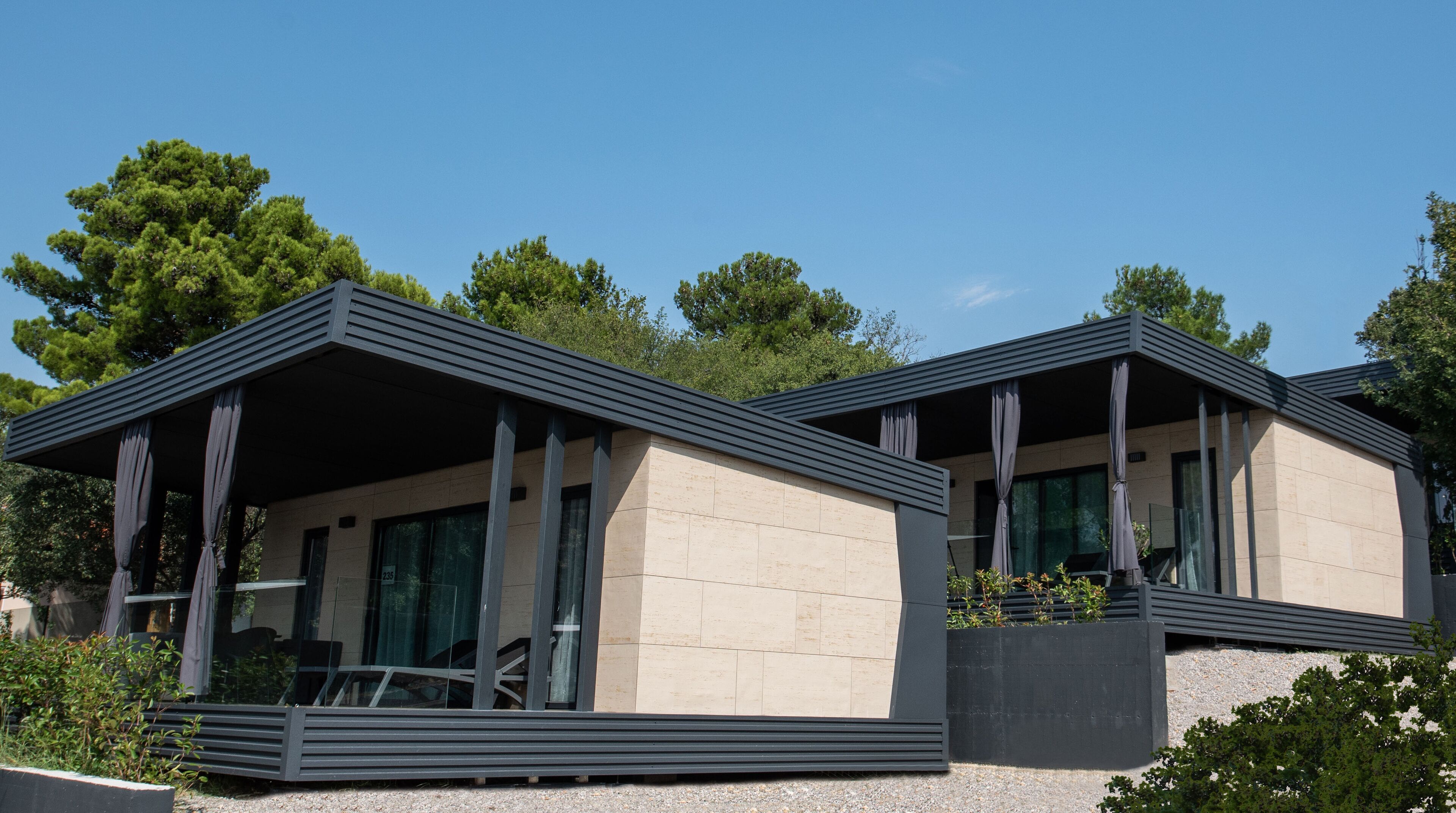Un bâtiment moderne à deux étages, doté d’un toit plat, de grandes fenêtres et d’un balcon.