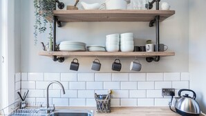 A kitchen with wooden shelves, a kettle, and a sink. - Charming and comfortable apartment, centrally located with easy parking access. Sleeps 4 (North Berwick)