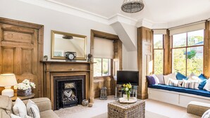 A living room with a fireplace, television, and seating area. - Charming and comfortable apartment, centrally located with easy parking access. Sleeps 4 (North Berwick)