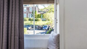 A room with a window seat, a view of parked cars and buildings outside. - Charming and comfortable apartment, centrally located with easy parking access. Sleeps 4 (North Berwick)