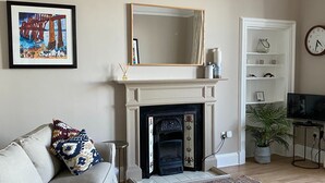 A living room with a fireplace, a sofa, a coffee table, and a rug. - Stunning sea views, dog friendly holiday accommodation in North Berwick (North Berwick)