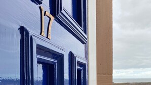 A blue door with a brass handle and a view of a road and sea in the background. - Stunning sea views, dog friendly holiday accommodation in North Berwick (North Berwick)