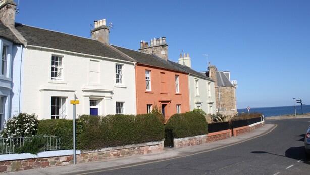 A row of colorful houses along a coastal road with a clear blue sky. - Perfectly located for town and beach - Victorian terraced house near East Beach. Sleeps 7 (North Berwick)
