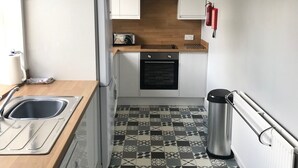A compact kitchen with a sink, a toaster, a refrigerator, an oven, and a trash bin. - Perfectly located for town and beach - Victorian terraced house near East Beach. Sleeps 7 (North Berwick)