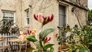 A rustic stone house with a garden patio, wooden chairs, and potted plants. - Stylish first-floor apartment with private patio, just moments from the High Street. Sleeps 2 (North Berwick)