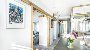 Una cucina moderna con travi a vista in legno, un lavello in acciaio inossidabile e un vaso di fiori sul bancone.