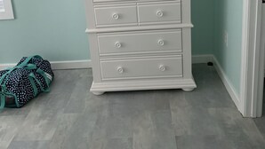 A white dresser with drawers, a teal wall, and an air conditioning unit above it. - Upstairs 3 BR, 2 bath home, 150 yds from beach with beautiful clear water. (Port Royale, South Bimini)