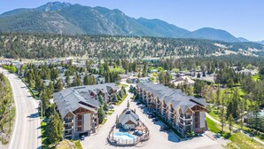 Ein Resort mit mehreren Gebäuden, einem Pool und einer Bergkulisse.