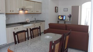 A compact kitchen with a dining area, a sofa, and a television. - Apartment - Standard Floor - Without Terrace (Raxó)