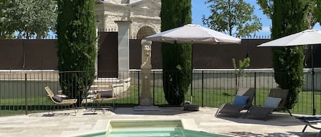 Piscine extérieure en saison, parasols, chaises longues