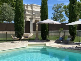 Una piscina al aire libre de temporada, sombrillas