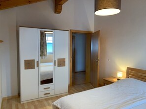 A bedroom with a bed, a wardrobe, a nightstand, and a lamp. - Hotel Restaurant tauernhex (Piesendorf)