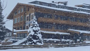 Un edificio de varios pisos con tejado nevado y un letrero que dice "tauer".