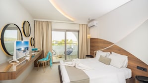 A modern hotel room with a large bed, a TV, a desk with a chair, and a balcony with a view. - Happy Days Hotel (Rhodes)