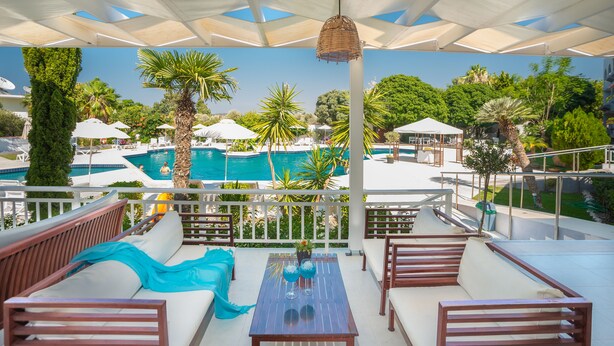 A rooftop lounge with a pool view, outdoor seating, and a pergola with umbrellas. - Happy Days Hotel (Rhodes)