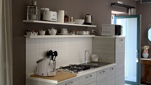 Une cuisine moderne avec des meubles blancs, une cuisinière à gaz et un four à micro-ondes.