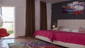 A bedroom with a large bed, two bedside tables, and a colorful rug. - Casa La Reforma TRINIDAD (Trinidad)