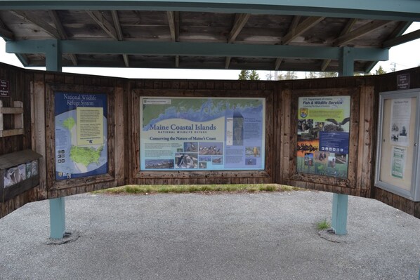 A wooden information board with maps and text about the Maine Coastal Islands National Wildlife Refuge System. - Quiet and Cozy Seaside Cottage with Amazing Sunsets (Steuben)