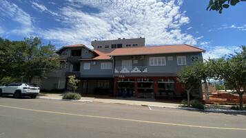A two-story building with a storefront labeled "FIKA" and a parking lot in front.