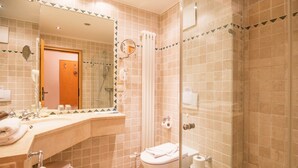 A bathroom with a shower, toilet, sink, and a mirror. - Apartment with 1 bedroom and balcony (Ostseebad Binz)
