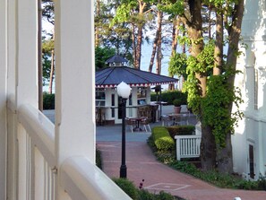 En terrasse med udendørs møbler, et overdækket område og en sti til en bygning.