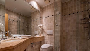Ein modernes Badezimmer mit einer Duschkabine, einem Waschbecken mit Spiegel und einer Toilette.