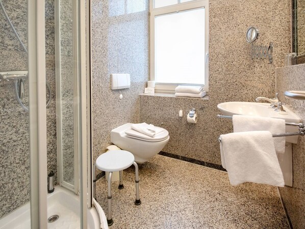 Un baño moderno con ducha, inodoro y lavamanos.