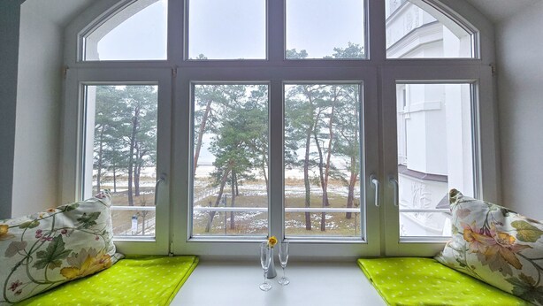 A bay window with a view of trees and a clear sky. - Apartment with sea view and 1 bedroom (Ostseebad Binz)