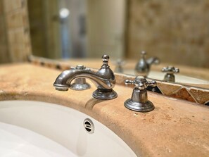 Un lavabo de salle de bain avec un robinet de style rétro et un miroir au-dessus.