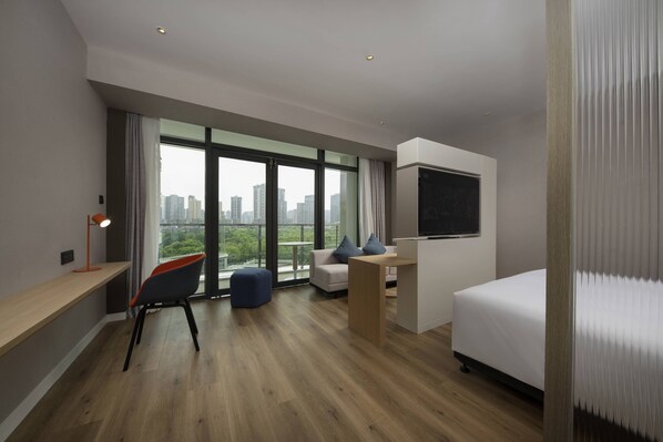 A modern hotel room with a large window, a bed, a desk, and a chair. - Holiday Inn Express Chongqing Caiyun Lake by IHG (Chongqing)