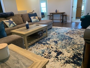 Un salon avec un canapé, une table basse et un tapis à motifs.