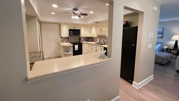 A modern kitchen with a central island, built-in appliances, and a ceiling fan. - Sarasota 3 bedroom villa conveniently located on Palm Aire Golf Course community (Sarasota)