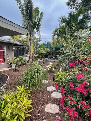 Stroll through the serene garden, surrounded by lush tropical plants and a majestic banana tree.