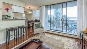 A modern apartment with a kitchen, dining area, and a large balcony with a city view.