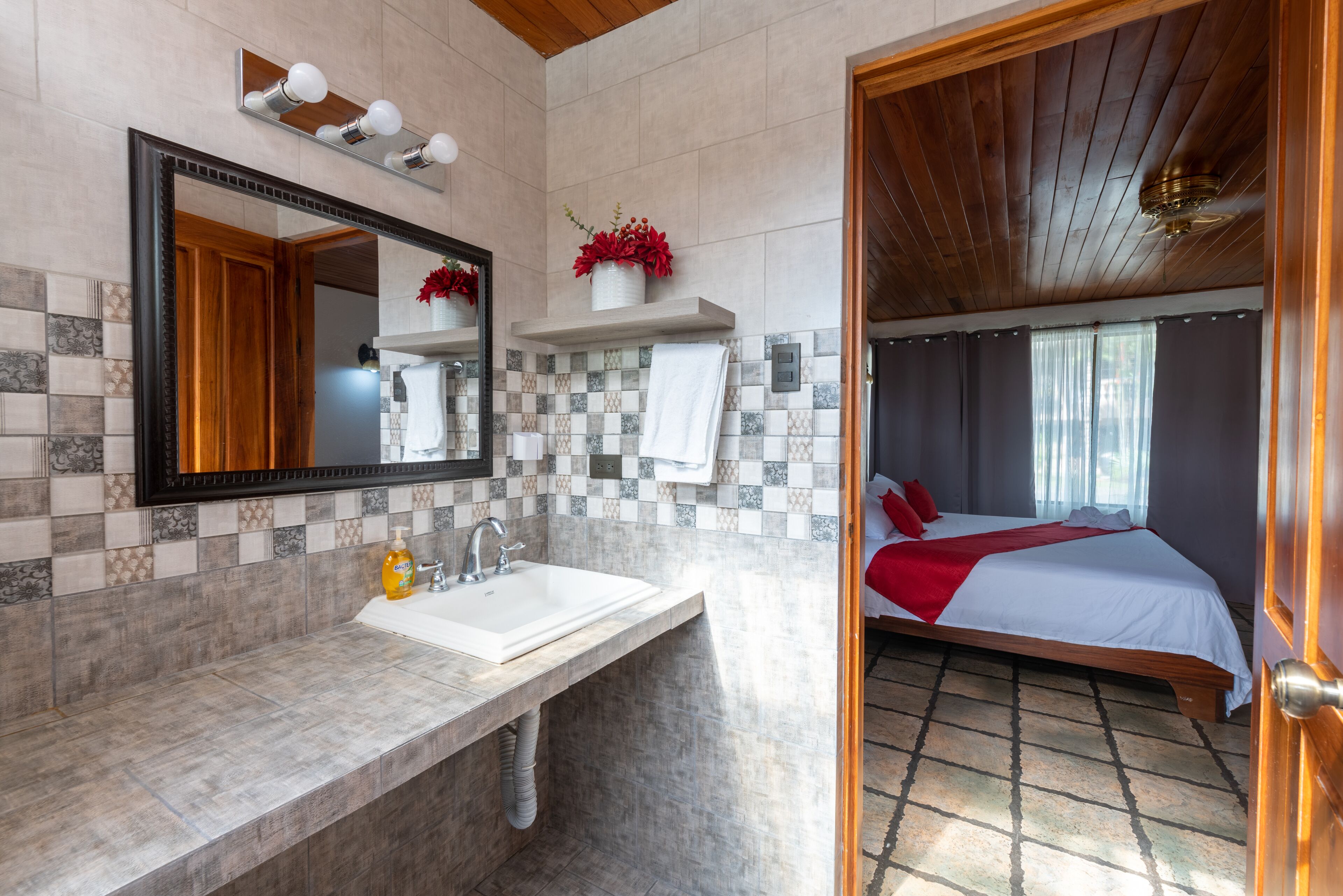 Une salle de bain avec un grand miroir, un lavabo et un espace douche.