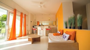 Een moderne woonkamer met een bank, salontafel en een eethoek met rode stoelen.