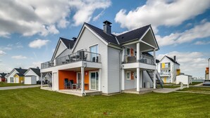 A modern two-story house with a balcony, a garage, and a well-maintained lawn. - Modern apartment with sea view, sauna and large balcony (Kappeln)