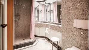 A bathroom with a shower, a sink, a toilet, and a mirror. - Classic apartment with 1 bedroom and balcony on the upper floor (Ostseebad Binz)