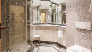 A modern bathroom with a glass-enclosed shower, a vanity with a mirror, and a towel rack. - Comfort plus apartment with 1 bedroom and balcony on the top floor (Ostseebad Binz)