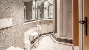A modern bathroom with a granite countertop, a white toilet, a sink, and a shower area. - Komfort Ferienwohnung mit 1 Schlafzimmer und Balkon im Obergeschoss (Ostseebad Binz)