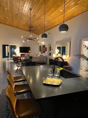 Relax in this inviting space with a large island table and comfortable seating, perfect for dining or socializing.
