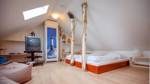 Un dormitorio con una cama, televisión, escritorio y ventana.