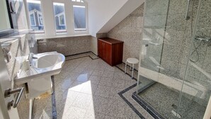 Ein modernes Badezimmer mit Duschkabine aus Glas, einem freistehenden Waschbecken und einem Waschtisch mit Spiegel.