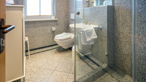 A modern bathroom with a toilet, sink, and shower area. - Comfort apartment with 2 bedrooms and terrace on the first floor (Ostseebad Binz)