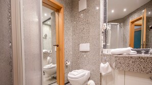 Un bagno moderno con un piano di lavoro in granito, un WC e un lavabo.