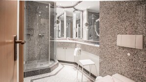 A modern bathroom with a glass-enclosed shower, a vanity with a mirror, and a toilet. - Comfort apartment with 1 bedroom and terrace on the first floor (Ostseebad Binz)